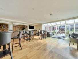 A bar area with stools and a counter at Marine Court First Floor Double with Shower Room in Littlehampton