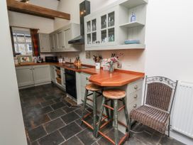 A kitchen with cabinets and a stove at 3 Christon Bank Mews Alnwick