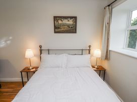 A bedroom with a bed, nightstands and lamps at 3 Christon Bank Mews in Alnwick