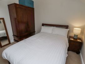 A bedroom with a bed, wardrobe, and lamp at 3 Christon Bank Mews Alnwick