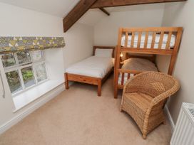 A bedroom with a bunk bed and a single bed at 3 Christon Bank Mews in Alnwick