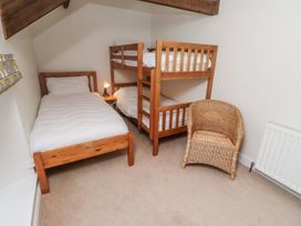 A bedroom with a single bed and a bunk bed at 3 Christon Bank Mews Alnwick