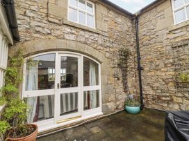 An outdoor area with a stone wall and a door at 3 Christon Bank Mews Alnwick