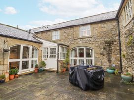 An outdoor area with stone walls and a patio at 3 Christon Bank Mews Alnwick