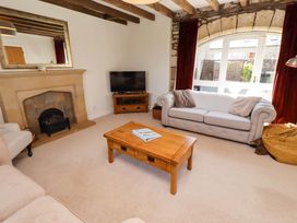 A living room with a sofa, coffee table, and television at 3 Christon Bank Mews, Christon Bank