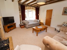 A living room with a sofa a coffee table and a television at 3 Christon Bank Mews Christon Bank