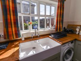 A kitchen with a sink and washing machine at 3 Christon Bank Mews Christon Bank