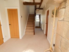 A hallway with a staircase and a coat rack at 3 Christon Bank Mews in Christon Bank