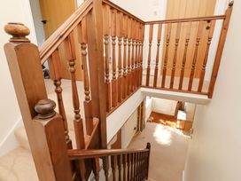 A staircase with wooden banister and door at 3 Christon Bank Mews Christon Bank