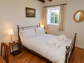 A bedroom with a bed and lamp at 3 Christon Bank Mews in Christon Bank