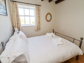 A bedroom with a bed and a window at 3 Christon Bank Mews Christon Bank