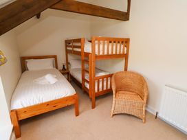 A bedroom with a single bed and a bunk bed at 3 Christon Bank Mews in Christon Bank