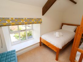 A bedroom with a bed and a bunk bed at 3 Christon Bank Mews in Christon Bank
