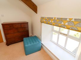 A bedroom with a chest of drawers and an ottoman at 3 Christon Bank Mews Christon Bank