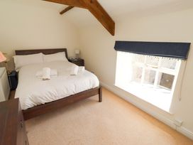 A bedroom with a bed and a window at 3 Christon Bank Mews in Christon Bank