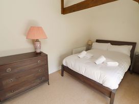 A bedroom with a bed and dresser at 3 Christon Bank Mews in Christon Bank
