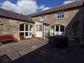 An outdoor area with a bench and stone walls at 3 Christon Bank Mews in Christon Bank