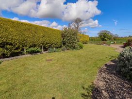 A garden with grass and shrubs at 3 Christon Bank Mews, Christon Bank