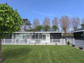 A single story house with white fencing and green grass in front at 99 Cherry Park in Chapel St Leonards