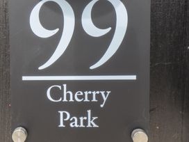 A black house number sign with the number 99 and the text Cherry Park at 99 Cherry Park in Chapel St Leonards