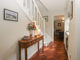 A hallway with a staircase and a console table at St. Marys House in Church Westcote near Bledington