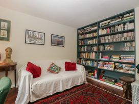 A living room with a sofa and bookshelf at St. Marys House in Church Westcote near Bledington