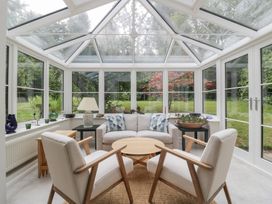 A conservatory with seating and plants at St. Marys House, Church Westcote near Bledington