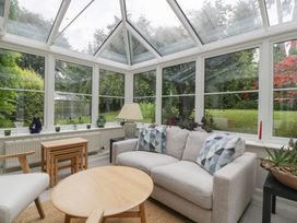 A conservatory with seating and tables at St. Marys House Church Westcote near Bledington