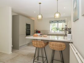 A kitchen with an island, chairs, and appliances at St. Marys House Church Westcote near Bledington