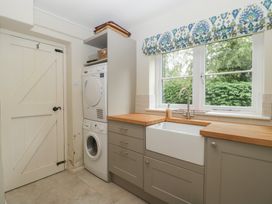 A utility room with a washing machine and sink at St. Marys House Church Westcote near Bledington