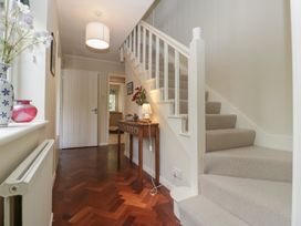 A hallway with a staircase and table at St. Marys House Church Westcote near Bledington
