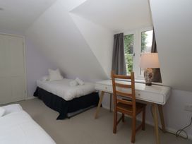 A bedroom with a bed and desk at St. Marys House Church Westcote near Bledington