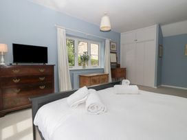 A bedroom with a bed and television at St. Marys House Church Westcote near Bledington