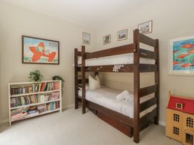 A bedroom with a bunk bed and bookshelf at St. Marys House Church Westcote near Bledington