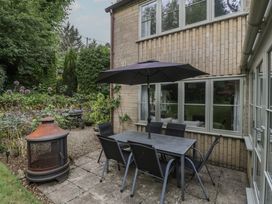 An outdoor patio with a table and chairs at St. Marys House Church Westcote near Bledington