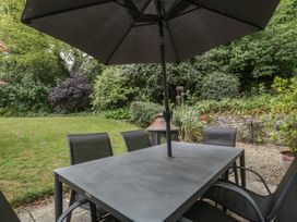 A garden table with chairs and an umbrella at St. Marys House in Church Westcote near Bledington