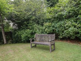 A bench in a garden surrounded by greenery at St. Marys House Church Westcote near Bledington