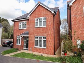 A red brick two-story house with white framed windows and a black front door at Peninsula Cottages - The Tors in Tavistock
