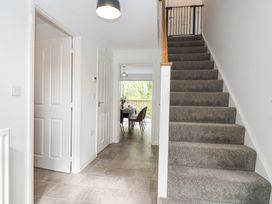 A hallway with tiled floor stairs and an open door showing a dining area at Peninsula Cottages - The Tors in Tavistock