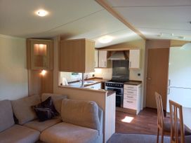 A living room with a kitchen and dining area at Emma No.6 Llandegfan