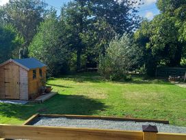 An outdoor space with a shed and grass area at Emma 6 in Llandegfan