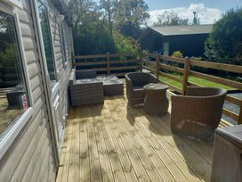 An outdoor seating area with wicker furniture at Emma 6 Llandegfan