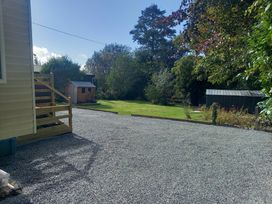 A garden with gravel area and a shed at Emma 6 in Llandegfan
