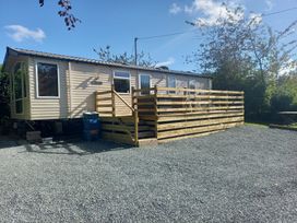 A caravan with a deck and gravel area at Emma 6 in Llandegfan
