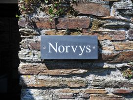 A sign reading Norvys on a stone wall at Norvys in Bossiney
