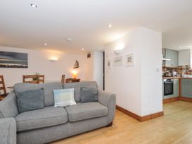A living room with a sofa and dining area at Norvys in Bossiney