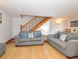 A living room with a staircase and seating at Norvys in Bossiney