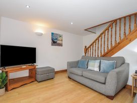 A living room with a sofa and television at Norvys in Bossiney