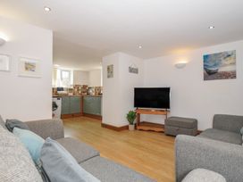 A living room with a tv and access to a kitchen at Norvys in Bossiney