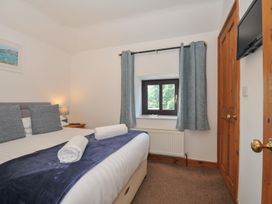 A bedroom with a bed and a window at Norvys in Bossiney